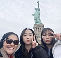 Woman stainding in front of Statue of Liberty